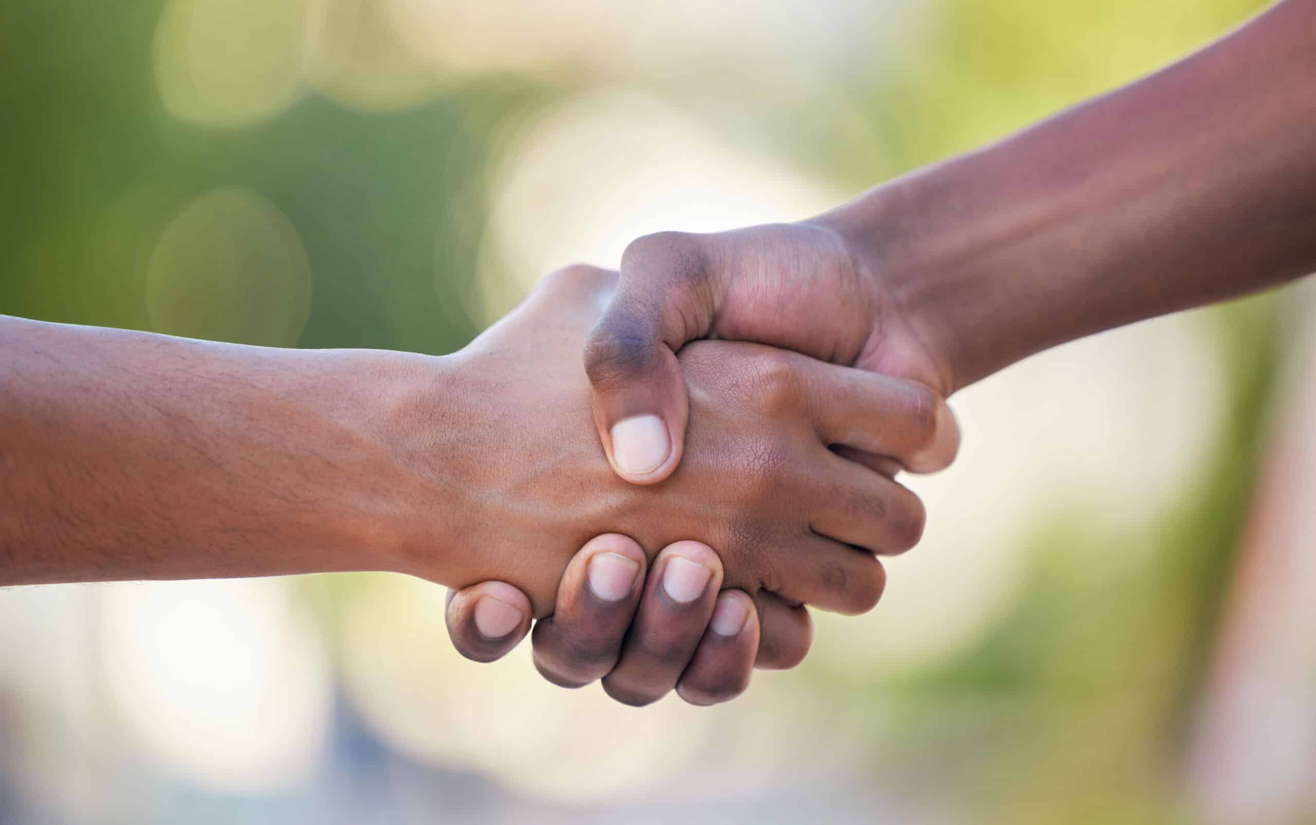 Hands, handshake and friendship in trust, support or care for relationship, agreement or unity agai.